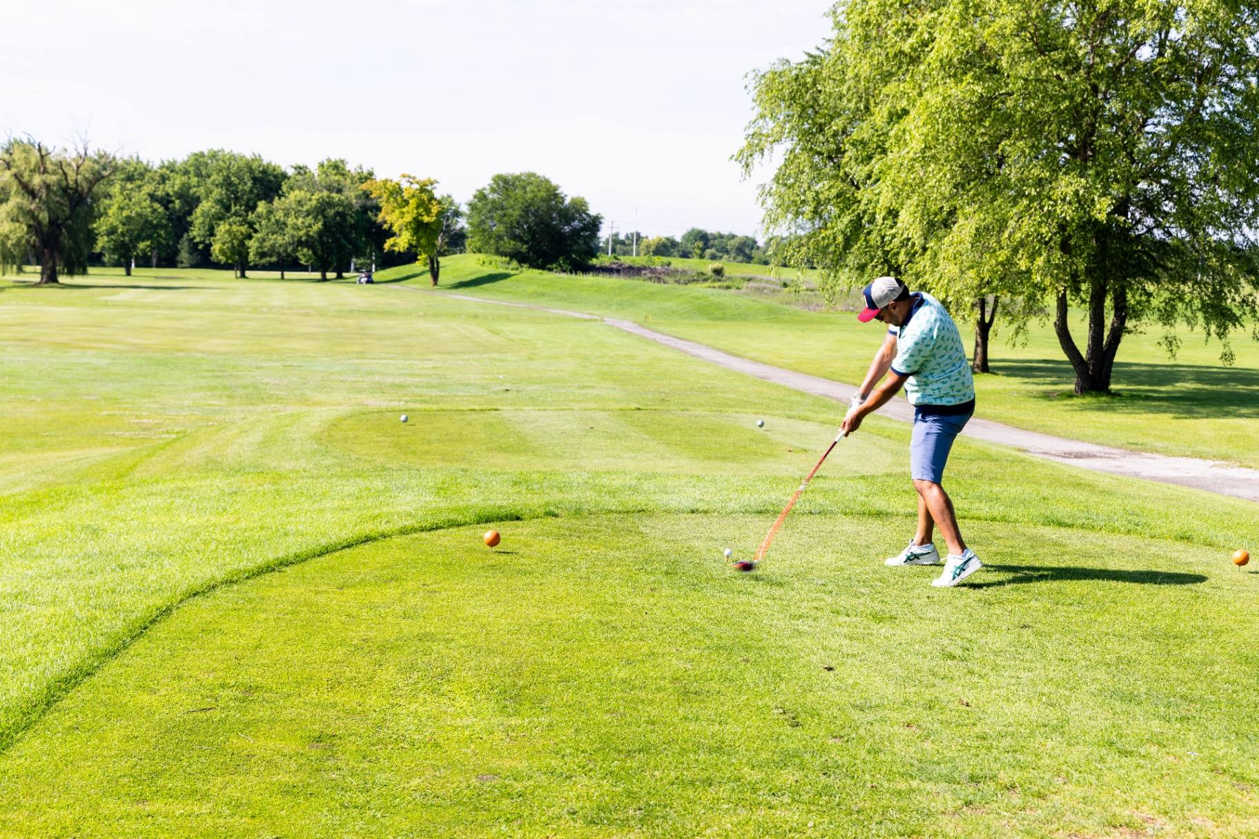 Golfer teeing off down the fairway
