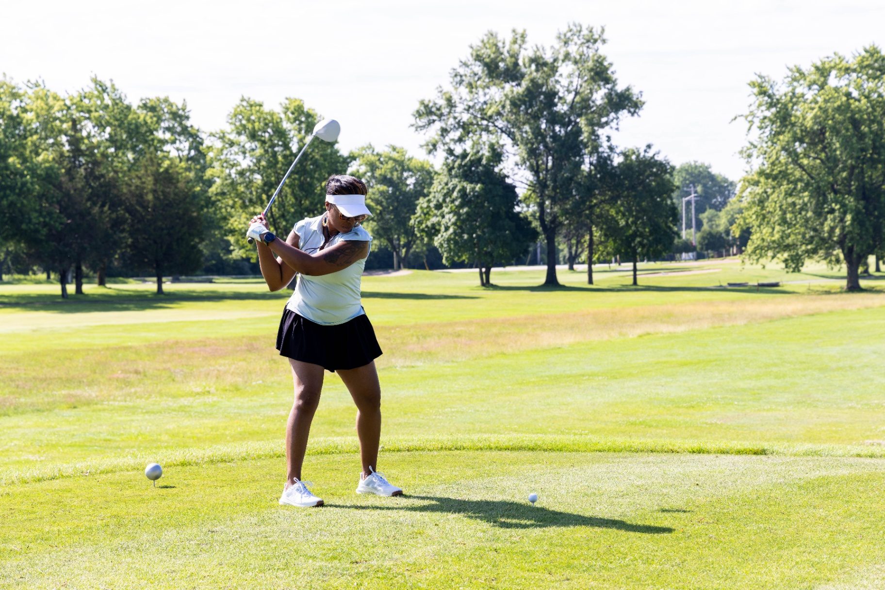 Golfer mid-swing on the tee box